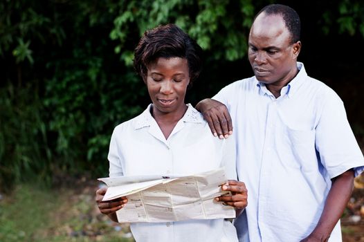 young couple traveling consult a regional  map in contryside.