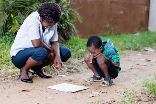 In travel and tourism, a young mother reads a map with her child in the country.