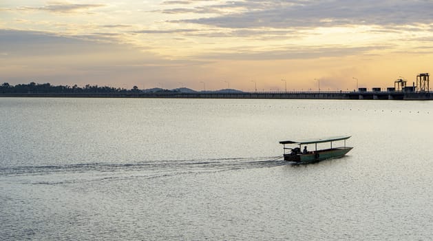 Passenger boats across the side of the dam. Evening atmosphere along the water in the dam. Sailing boat to transport people across the canal In the water storage dam