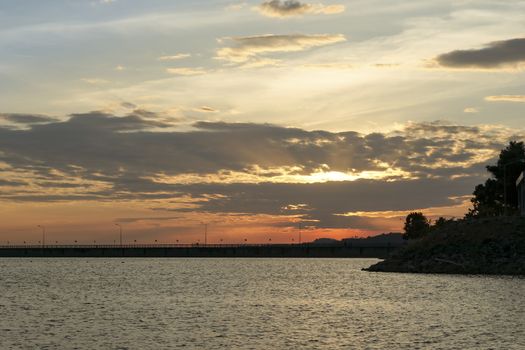 Sunset at the dam collecting water. Orange evening sky