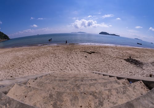 The stairs down to the beach. The beach with the sky and the blue sea.
