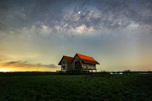 Milky Way , old abandoned house, red roof on open field