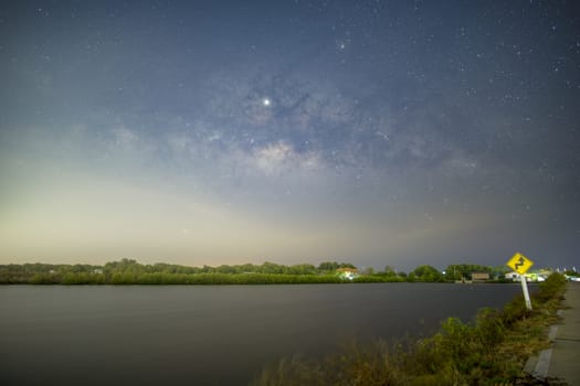 Signs, signs, beware of curves at night, behind the sign, with the Milky Way.	