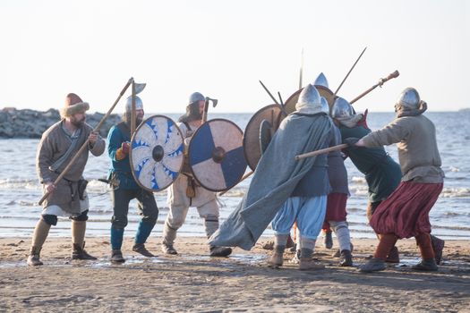 Slavic warriors reenactors with wearpons and shields training fighting outdoors at seaside