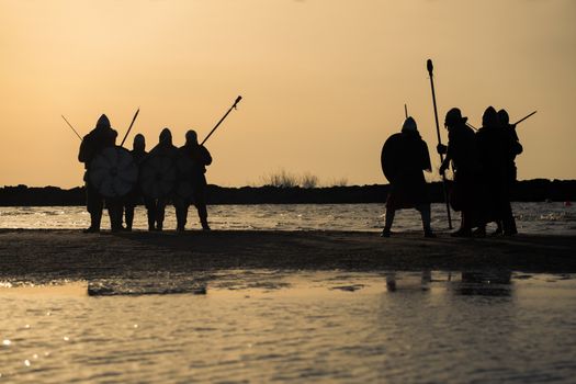 Slavic warriors reenactors with wearpons and shields training fighting outdoors at seaside