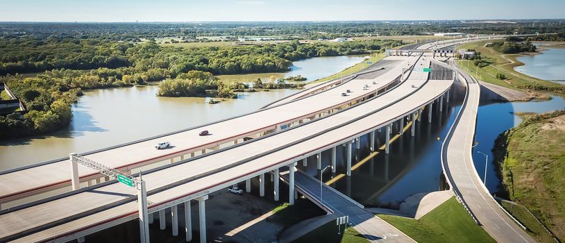 Panorama aerial view elevated highway viaduct through flood area near Dallas, Texas, USA. Top of multilevel expressway near a lake
