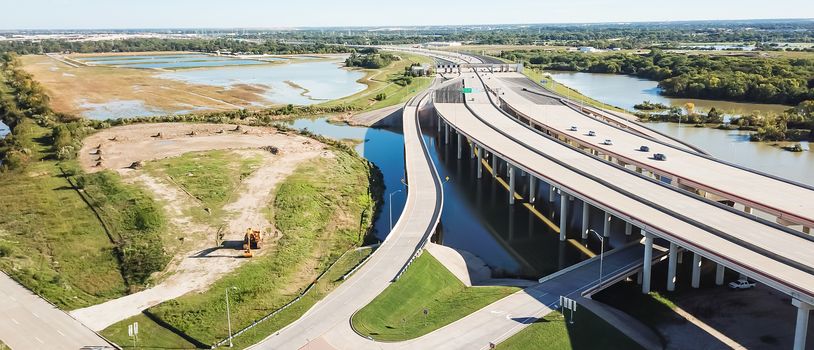 Panorama aerial view elevated highway viaduct through flood area near Dallas, Texas, USA. Top of multilevel expressway near a lake