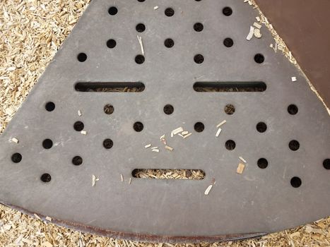 brown metal step on play stucture with holes that looks like a face