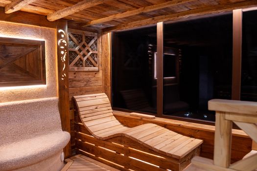 Handmade bath in the spa complex. The bath is trimmed with planks and hay.