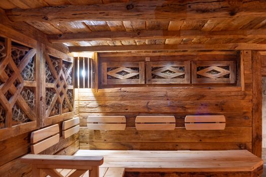 Handmade bath in the spa complex. The bath is trimmed with planks and hay.