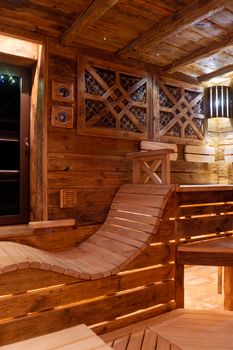 Handmade bath in the spa complex. The bath is trimmed with planks and hay.