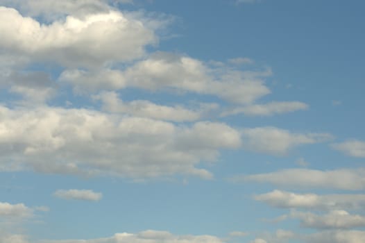 White cumulus clouds against a blue sky.