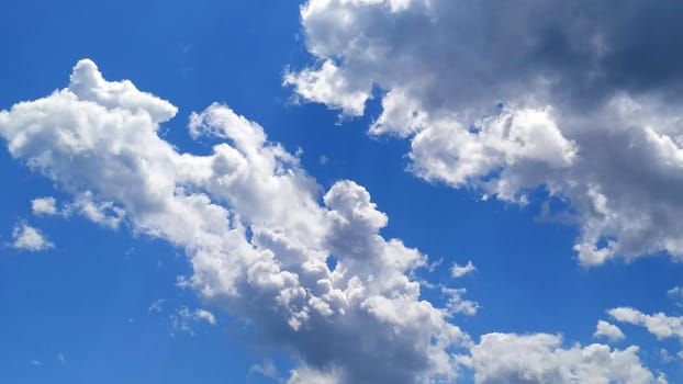 White cumulus clouds against a blue sky.