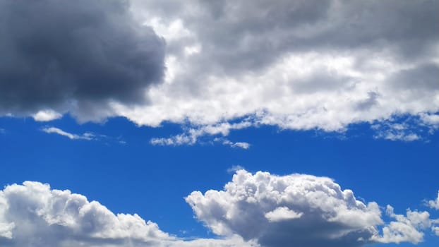 White cumulus clouds against a blue sky.