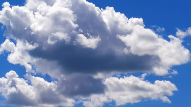 White cumulus clouds against a blue sky.