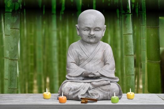 Buddha stone statue child bamboo background blur lit candles and incense