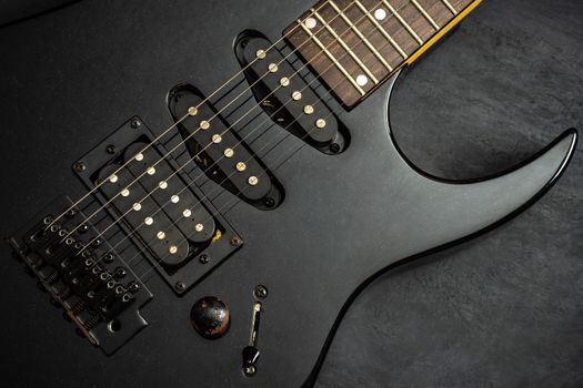 Black electric guitar on black cement floor. Top view and copy space for text. Concept of rock music.