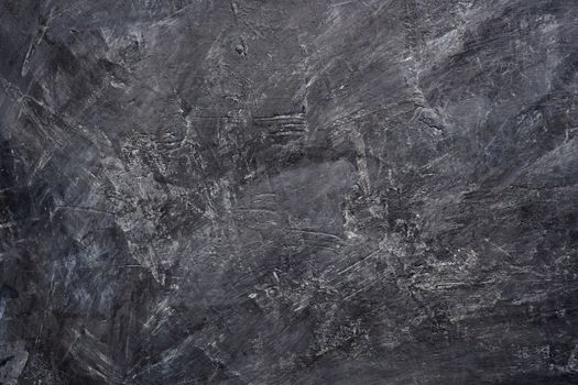 Close up texture of black color painting on cement wall.