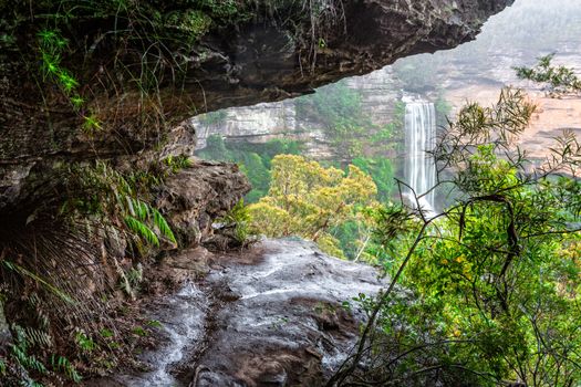 Waterfall viewed through the unfenced ledges of the escarpment cliffs