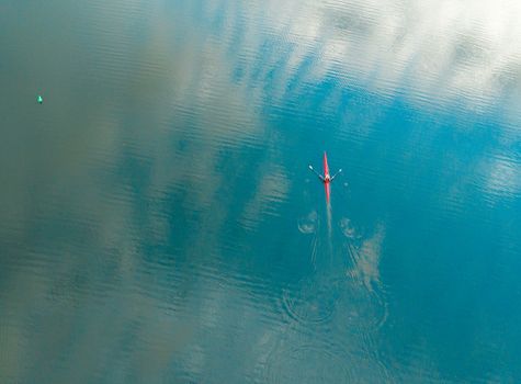 Kayaker rowing along the river.  Aerial top down with space for copy