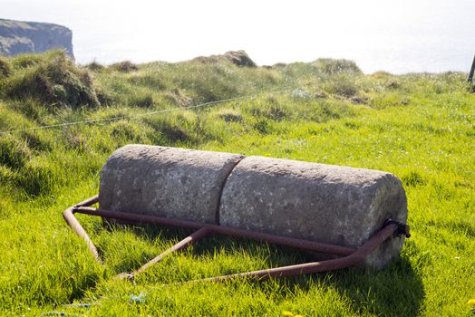 old rustic concrete roller abandoned at a field in ireland