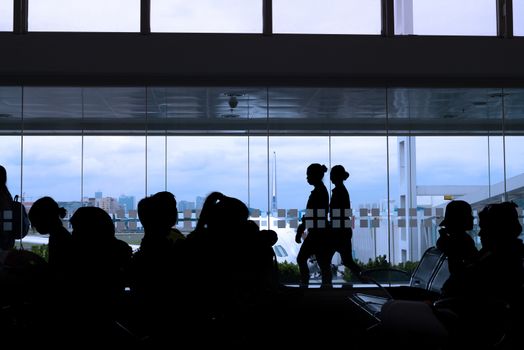 silhouette of crew and passengers at an airport lounge