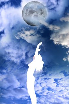 attractive silhouetted nude woman holding her hands up to the sky giving gratitude to the moon in a yoga pose with a cloudy background