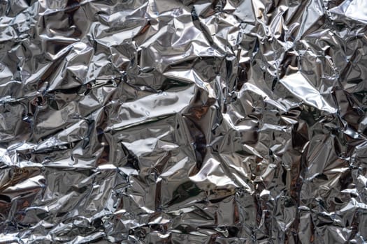 Texture of crumpled silver foil plastic. Concept of global warming.