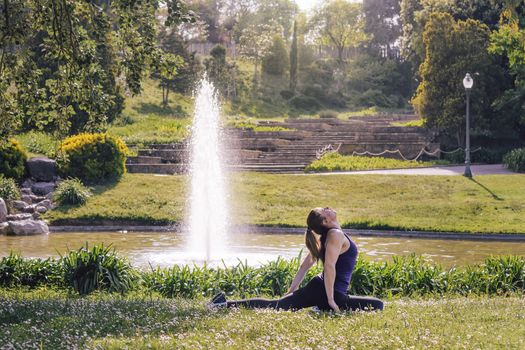 young sporty girl doing meditation yoga exercises and relaxing outdoors in the park, modern healthy lifestyle and sport concept