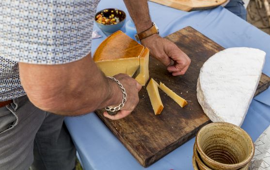 man cutting the famous dutch old cheese