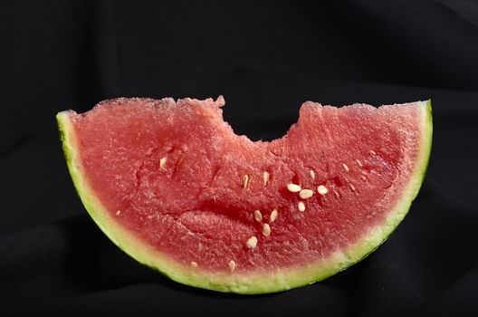 Image slice of watermelon with bite black background