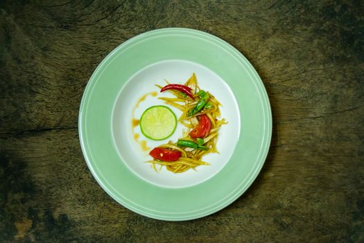 Thai spicy papaya salad on wood table (Som Tam Malakor)