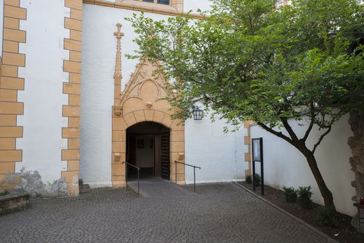 entrance of a church in trier with patio garden with tree and plants