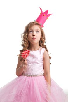 Beautiful little candy princess girl in crown holding big pink heart shaped lollipop