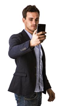 Handsome man taking selfie photo on cell phone or mobile, on black background in studio shot. Looking at cellphone