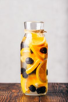 Bottle of Infused Water with Sliced Raw Orange and Fresh Blackberry.