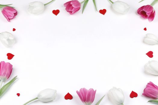 Pink and white tulip flowers and hearts over white background border frame with copy space isolated on white Valentines day concept