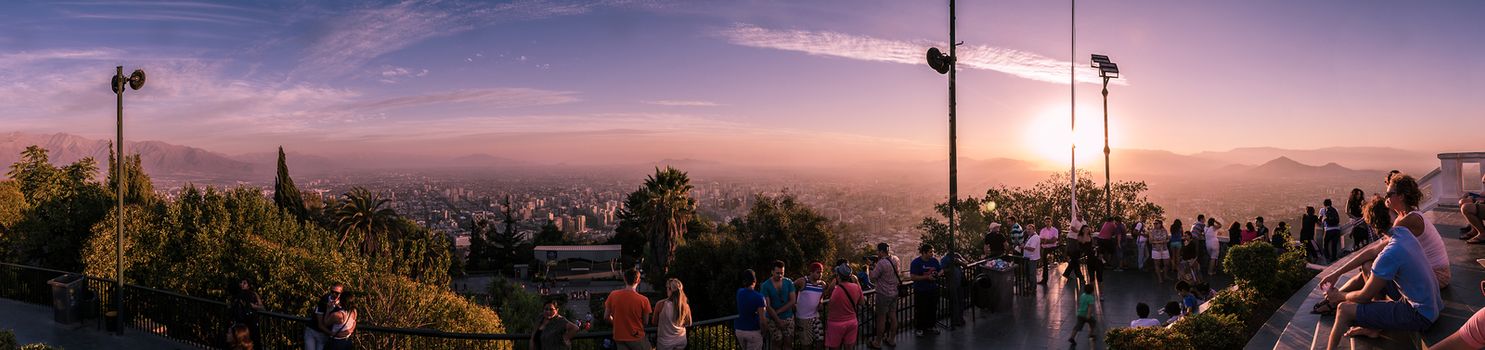 Many tourists enjoying a beautiful sunset from Cerro San Cristobal in Santiago de Chile