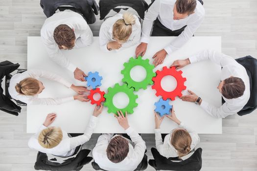 Business team meeting cooperation concept top view group people on table with cogwheels