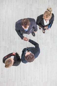 Business people shaking hands, finishing up a meeting, top view