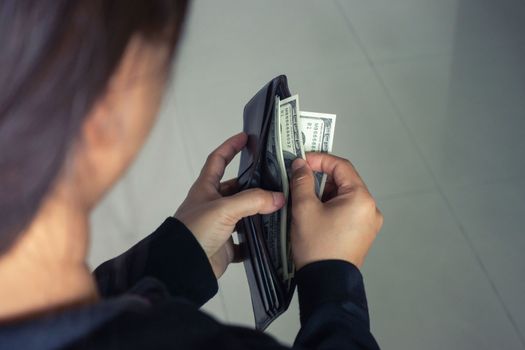 woman taking out money dollar banknotes from wallet