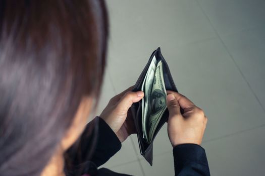 woman taking out money dollar banknotes from wallet