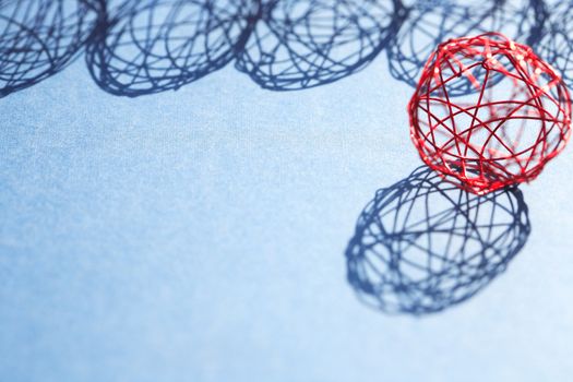 Set of red balls made from wire in a row against sun light