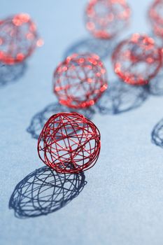 Set of red balls made from wire in a row against sun light
