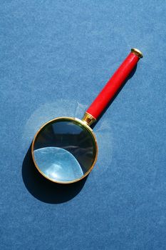 Nice retro magnifying glass under sunlight on gray background