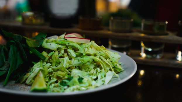 Set of shots in one row, six servings on a wooden stand and grren salad. Drink for the menu restaurant, bar, cafe