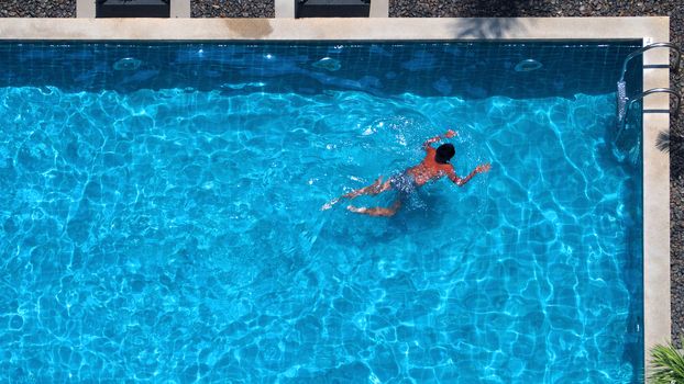 Swimming pool top view angle which blue color clear water and sun light reflect on surface texture and concept images for relaxation or vacation or sport in the tropical summer and for healthy lifestyle