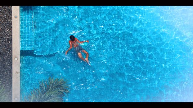 Swimming pool top view angle which blue color clear water and sun light reflect on surface texture and concept images for relaxation or vacation or sport in the tropical summer and for healthy lifestyle