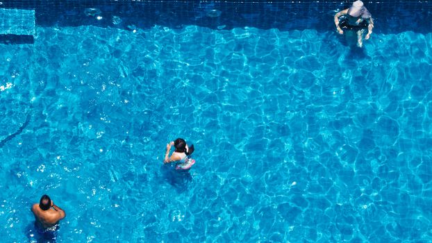 Swimming pool top view angle which blue color clear water and sun light reflect on surface texture and concept images for relaxation or vacation or sport in the tropical summer and for healthy lifestyle