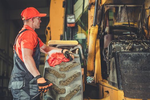 Small Tractor Bulldozer Engine Repair. Caucasian Professional Mechanic and His Job. Heavy Equipment Service Center.